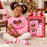 Smiling little girl holding a reindeer plush beside her Dream's Sugar Plum Christmas gift box