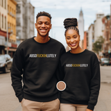 Two people wearing black sweatshirts with a humorous text design on a city street.