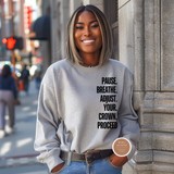 Woman wearing a sweatshirt with motivational text on a city street