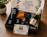 Father's Day gift basket with 'Best Dad Ever' tumbler, chocolate, and sparkling wine on a wooden surface.