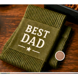 Green socks with 'Best Dad' text on a wooden surface