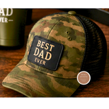 Camouflage cap with 'Best Dad Ever' patch on a wooden surface