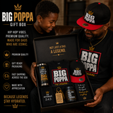 Father and Son holding a 'BIG POPPA' gift box with tumbler, cap, and card.