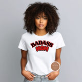 Woman wearing a white t-shirt with 'BADASS MOM' text, standing against a gray background.
