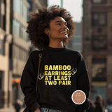 Woman wearing a black sweatshirt with yellow text in an urban setting