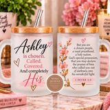 Two frosted glass mugs with bamboo lids and metal straws, displayed side by side on a marble surface with decorative books and flowers in the background. The left mug features the text 'Ashley is chosen.