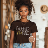 Woman wearing a brown 'Daughter of the King' t-shirt with a blurred background