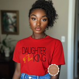 Person wearing a red 'Daughter of the King' t-shirt with a blurred background