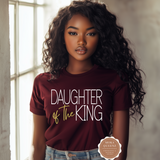 Woman wearing a 'Daughter of the King' t-shirt with a visible brand logo.