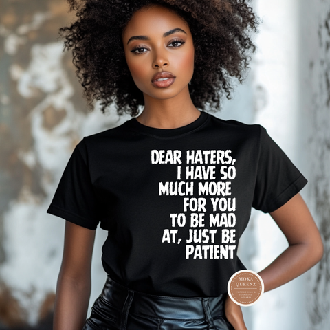 Person wearing a black t-shirt with a quote, standing against a neutral background