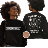 Person wearing a black hoodie with 'Supernatural' text on the front and 'Psychic AF' design on the back.