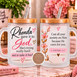 Two frosted glass mugs with bamboo lids and clear straws, displayed side by side on a marble countertop. The left mug features the inspirational quote 'Rhonda gave it to God.