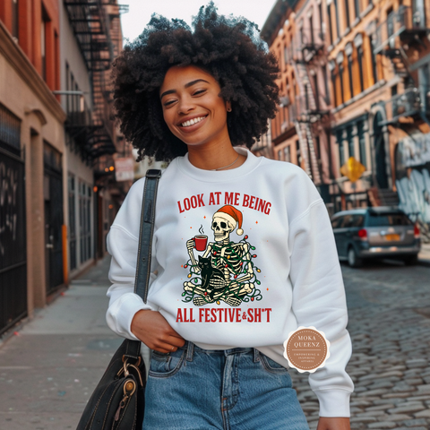 Woman wearing a white sweatshirt with a festive skeleton design on a city street.