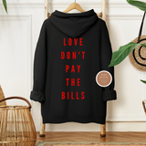 Black hoodie with red text on a wooden hanger against a neutral wall.
