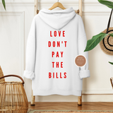 White hoodie with red text 'LOVE DON'T PAY THE BILLS' on a wooden hanger against a neutral wall.