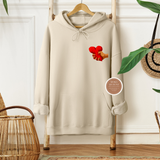 Beige hoodie with a graphic design on a wooden hanger against a white wall.