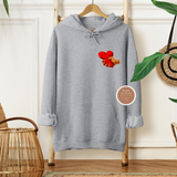 Gray hoodie with a design of hands holding a heart on a hanger against a neutral background.