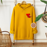 Yellow hoodie with a heart design on a hanger against a white wall.