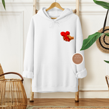 White hoodie with a graphic design on a hanger against a neutral wall.