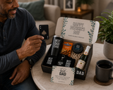 Man holding a card with a playing card design, surrounded by a 'Happy Father's Day' gift box with beer and snacks.