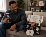 Man holding a 'Best Dad Ever' mug with a Father's Day gift basket on a couch.
