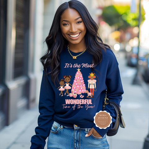 Woman wearing a navy blue sweatshirt with Christmas design on a city street
