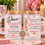 Two frosted glass mugs with bamboo lids and metal straws displayed side by side on a marble surface. The left mug reads 'Dawn Prayed For This Now she's living in the answer.