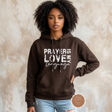 Prayer Is My Love Language hoodie in chocolate brown with distressed white typography, modeled
