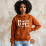 Prayer Is My Love Language hoodie in deep orange with distressed white typography, modeled