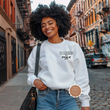 Woman wearing a white sweatshirt with text on a city street