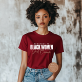 Woman wearing a red t-shirt with text, standing against a textured wall.