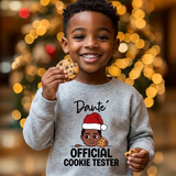 Toddler boy holding a cookie wearing a gray personalized Christmas sweatshirt with the name Dante above the words Official Cookie Tester