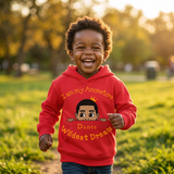 Laughing Black toddler boy running in a park wearing a red I Am My Ancestors Wildest Dream hoodie with the name Dante