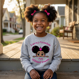 Laughing Black girl on a front porch wearing a sport gray I Am My Ancestors Wildest Dream sweatshirt with the name Ava