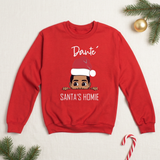 Red boys personalized Christmas sweatshirt flat lay with Santa's Homie design, pine sprigs, and candy cane