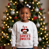 Toddler girl wearing a white personalized Christmas sweatshirt with the name Ava above the words Santa's Sweetie
