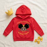 Red I Am My Ancestors Wildest Dream toddler girl hoodie flat lay with a yellow toy crown and bows