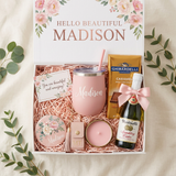 Hello Beautiful personalized gift box for Madison with a pink name tumbler, floral mirror, candle, tassel sanitizer keychain, full-size Ghirardelli caramel candy bar, and a mini Martinelli's Sparkling Cider