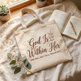 God Is Within Her tote bag flat lay on linen with a devotional journal and gold cross necklace