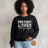 Model wearing a black Prayer Is My Love Language crewneck sweatshirt with distressed white typography