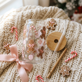 Gingerbread glass can flat lay with bamboo lid, glass straw, cleaning brush, and gingerbread cookies on a knit blanket