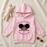 Light pink I Am My Ancestors Wildest Dream toddler girl hoodie flat lay with a stuffed bunny and sunglasses