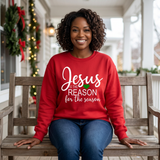 Black woman seated on a holiday porch bench in a red Jesus Is the Reason for the Season sweatshirt.