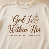 Close-up of the God Is Within Her Psalm 46:5 print on a cream t-shirt