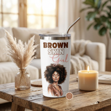 Brown Skin Girl white insulated tumbler with lid and metal straw on a coffee table beside a candle
