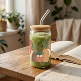 Boho botanical glass filled with iced matcha latte beside an open book.