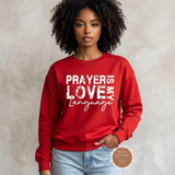 Prayer Is My Love Language sweatshirt in red with distressed white typography, modeled