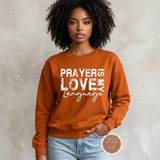 Prayer Is My Love Language sweatshirt in deep orange with distressed white typography, modeled