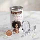 Brown Skin Girl white tumbler with its clear lid and reusable metal straw beside it on marble