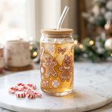 Gingerbread glass can cup at an angle on marble with mini candy canes beside it